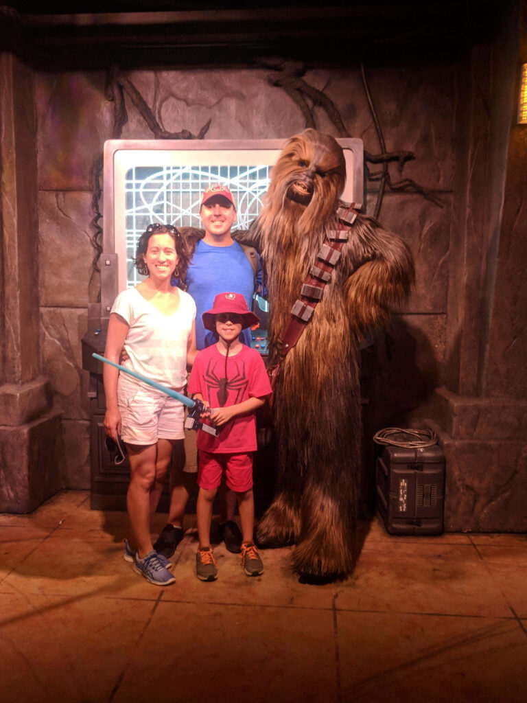Stacy with her husband and son posing with Chewbacca at Disney, the trip referenced in this post.